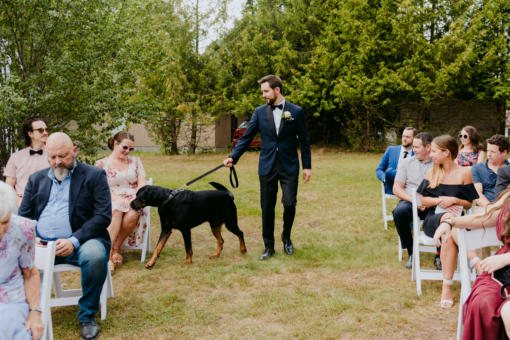 groom and his dog walking down the aisle during wedding ceremony
