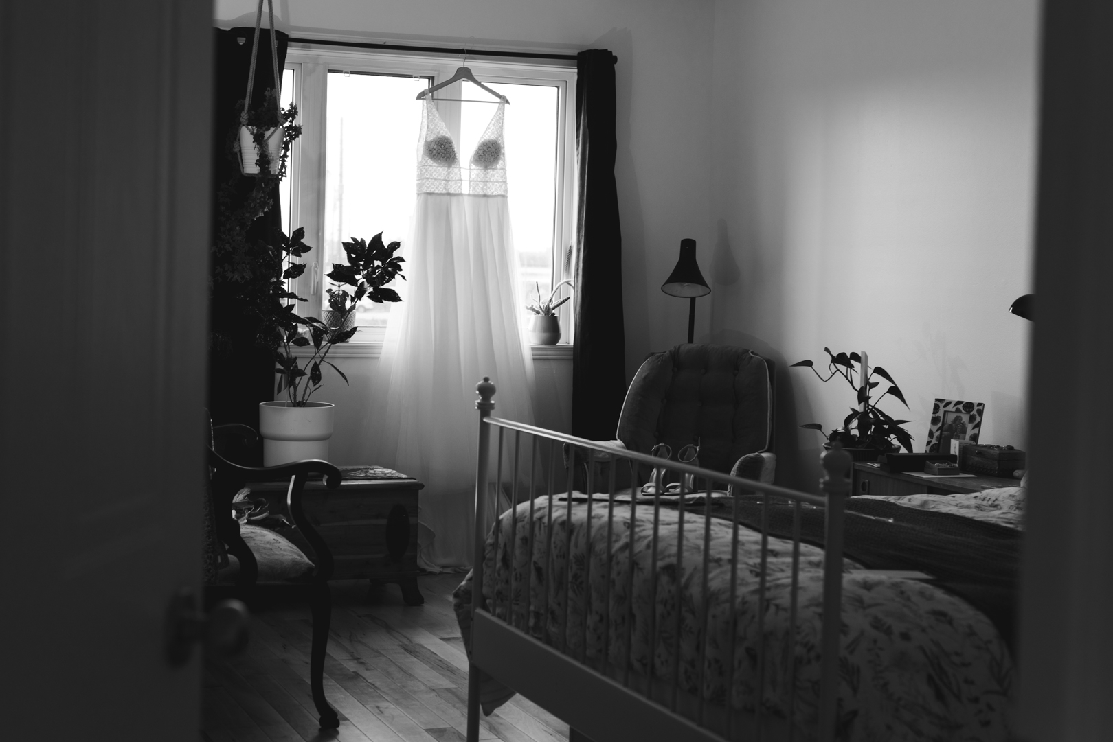 wedding dress hanging from bedroom window in black and white