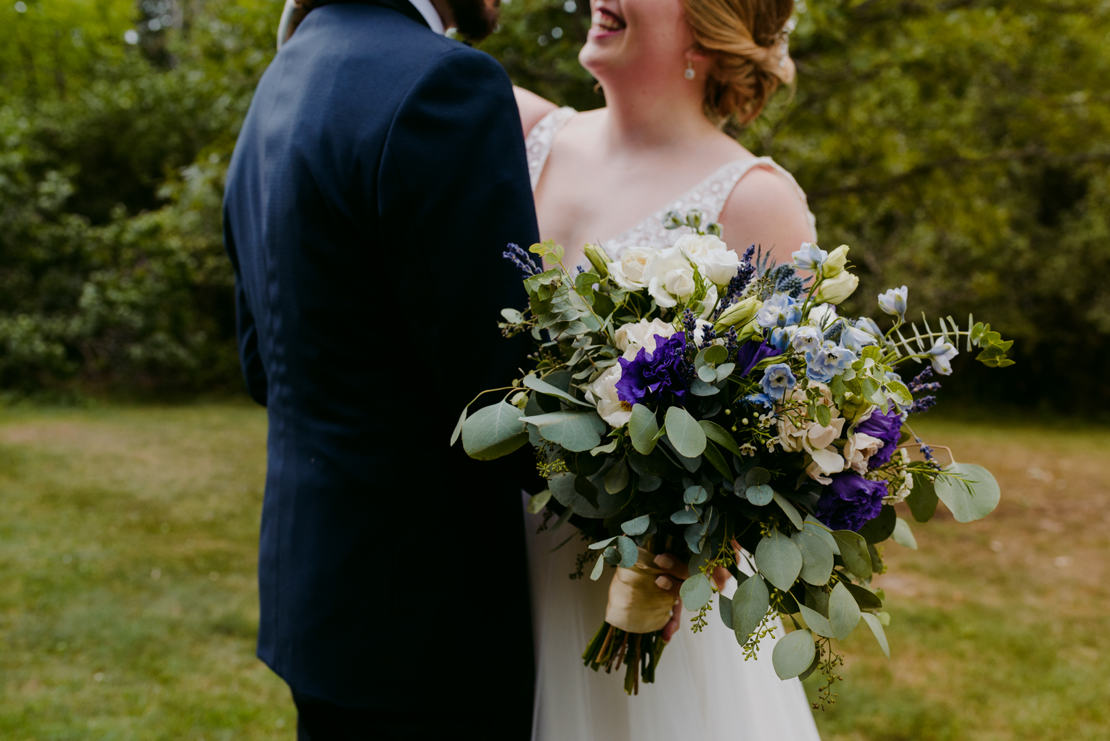 bride holding purple and green wedding bouquet