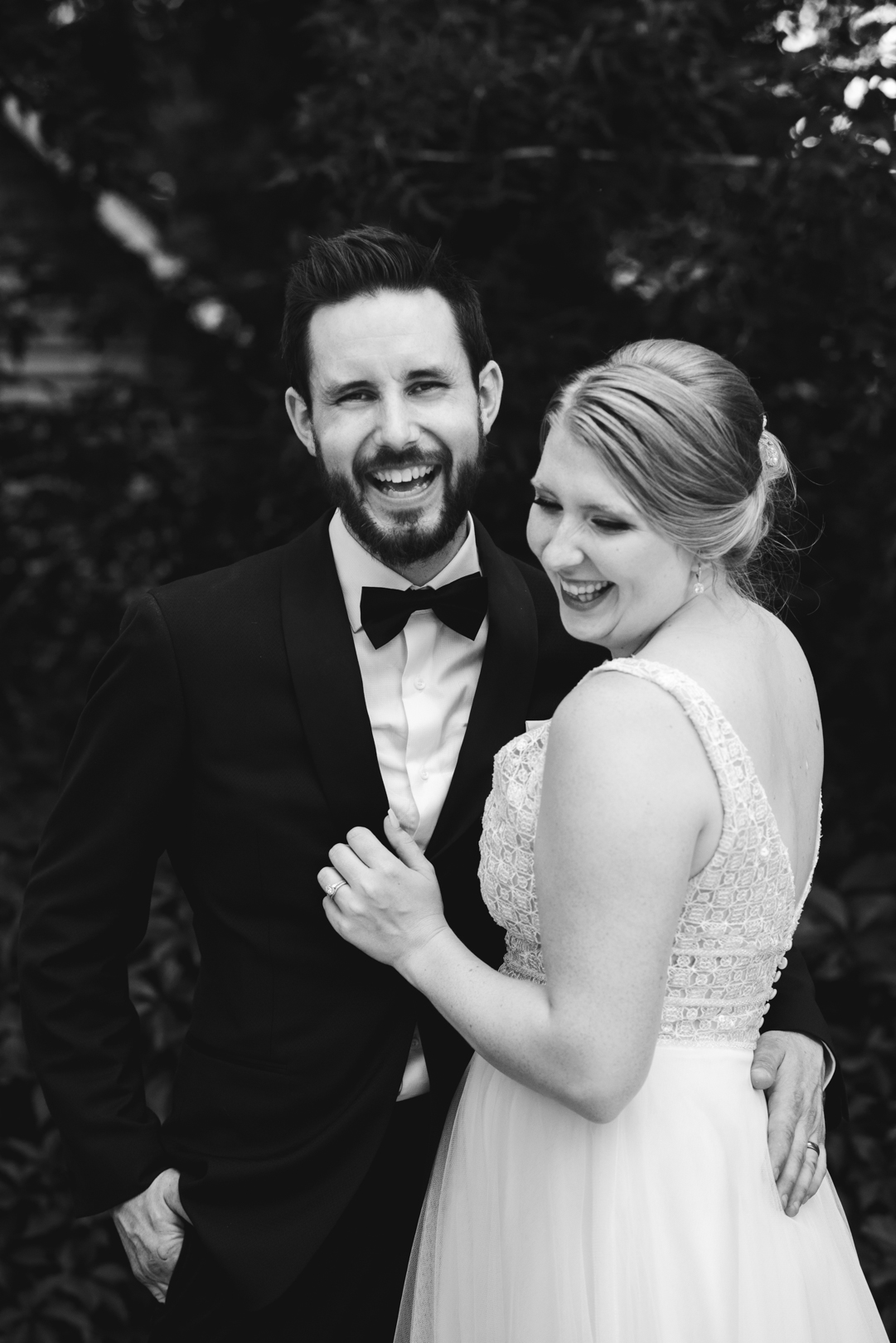 bride and groom laughing in black and white