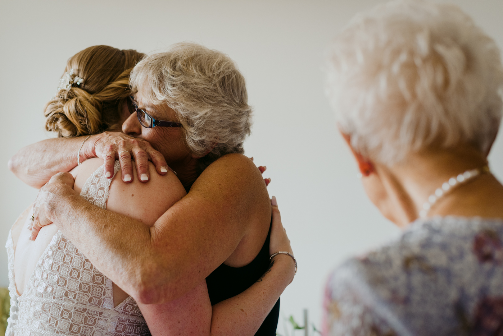 mother of the bride hugging mom after helping her into her dress