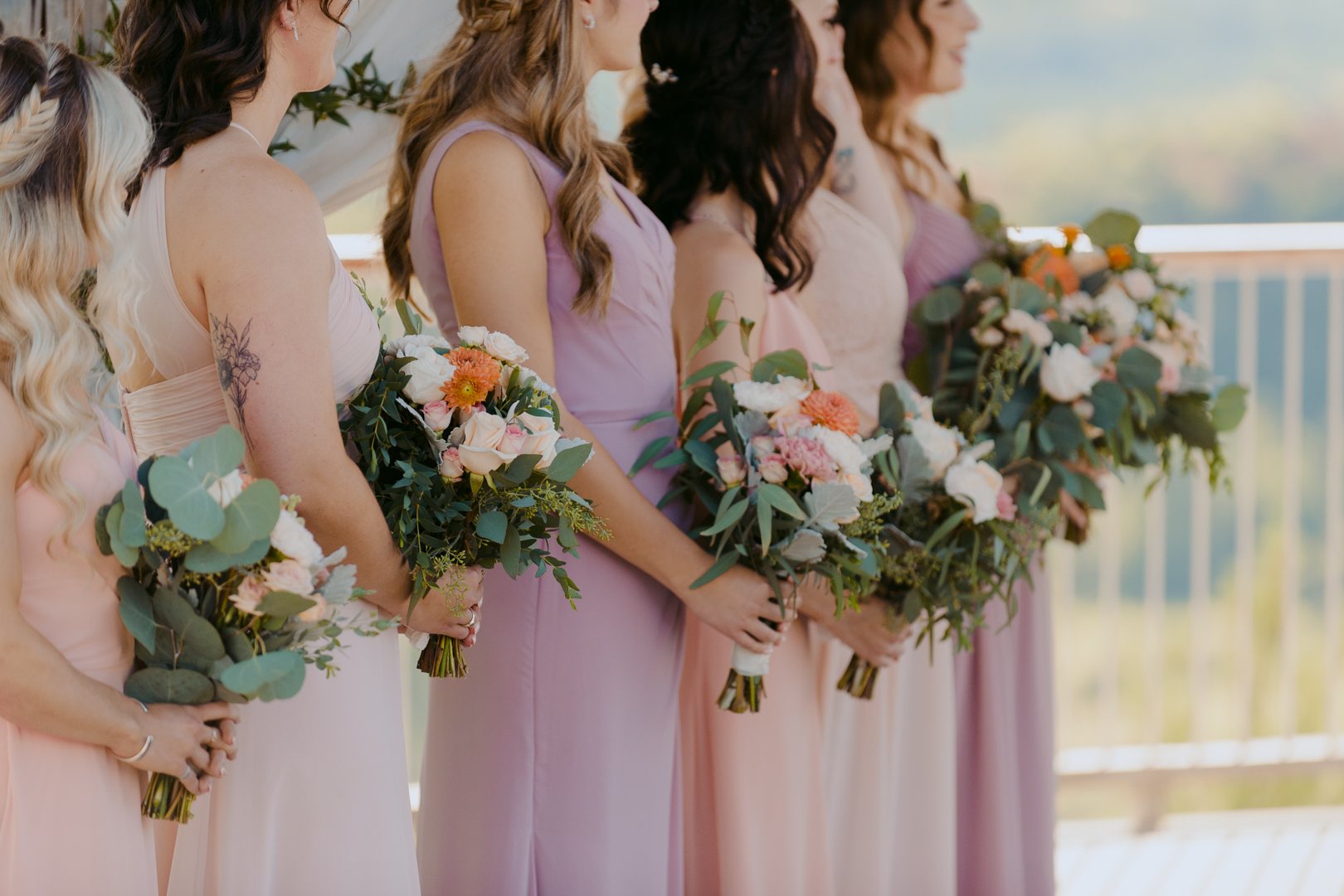 bridesmaids in pastel dresses holding bouquets during wedding ceremony at le belvedere