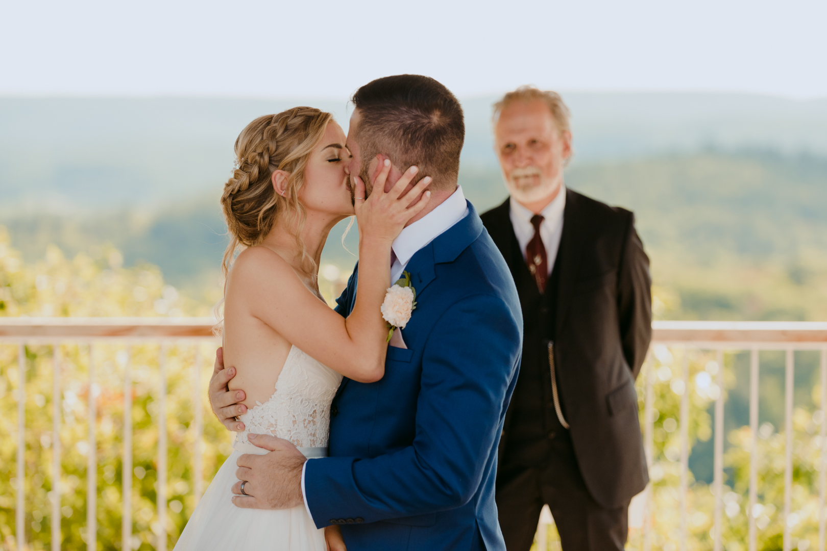 bride and groom first kiss during outdoor wedding ceremony at le belvedere