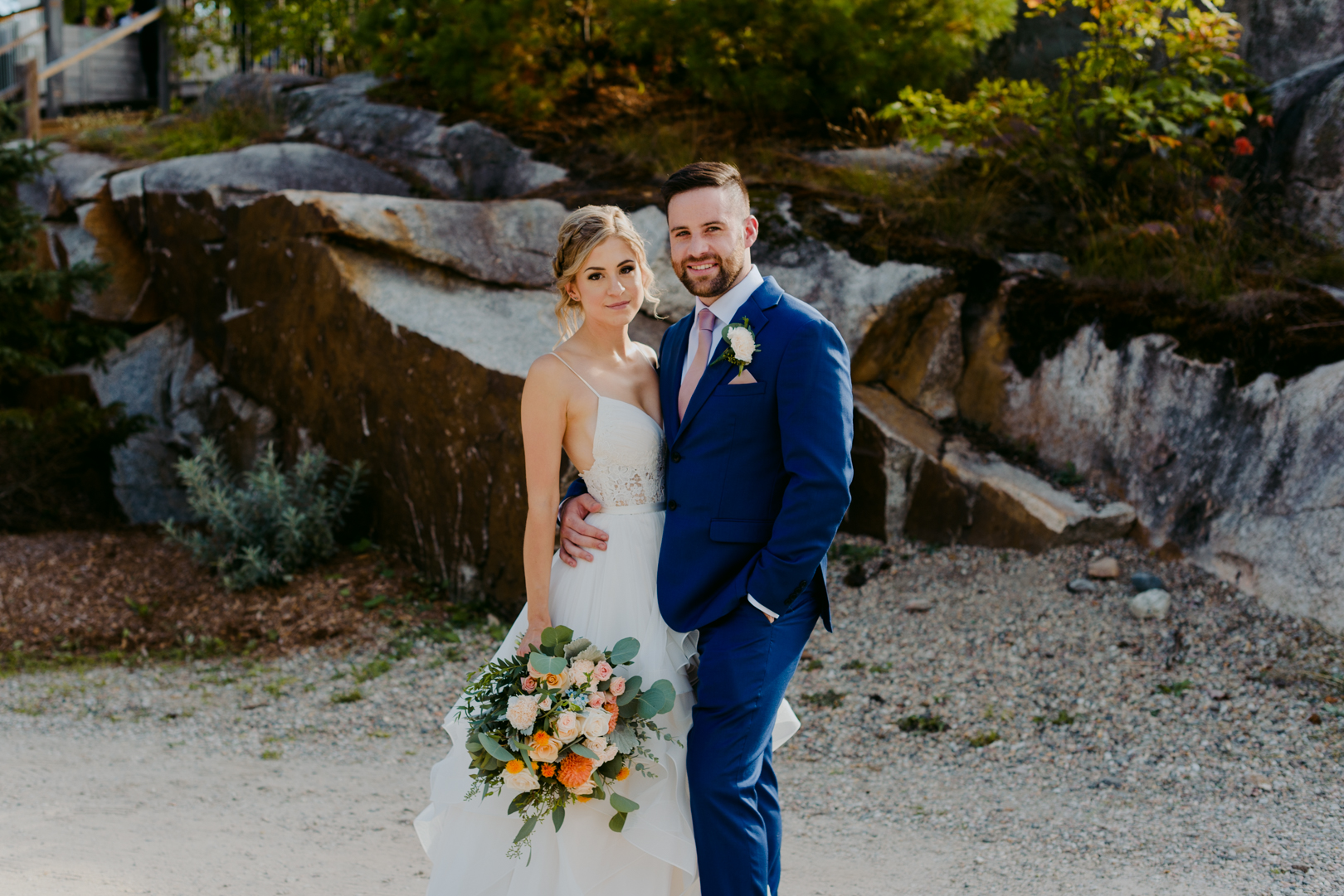 bride and groom with wild floral bouquet at le belvedere wedding in front of rock boulders