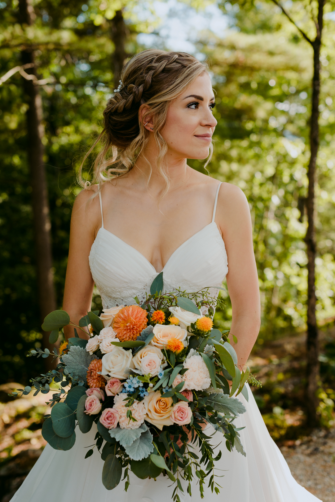 bride holding wild floral bouquet in a forest at le belvedere wedding