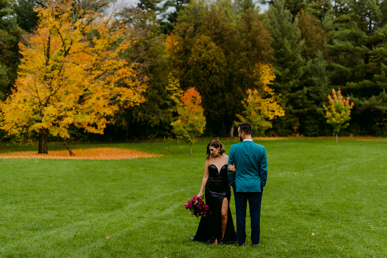 bride and groom in rockliffe park amongst fall coloured trees