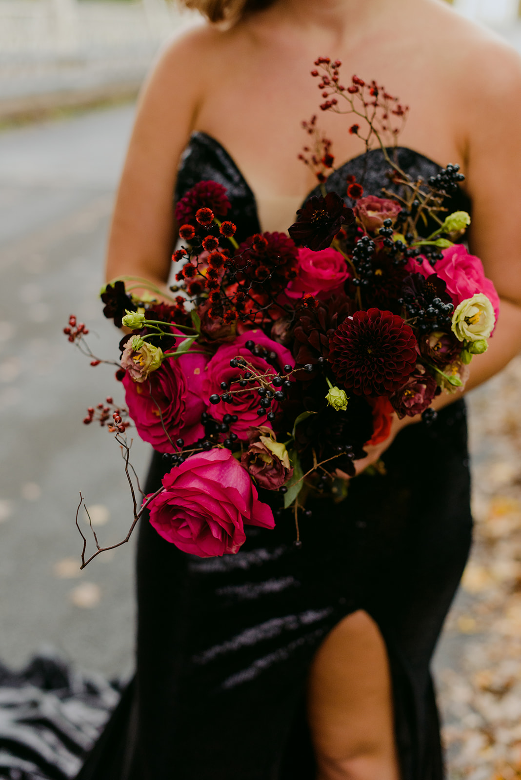 bride holding wild bouquet of flowers in black sequenced dress
