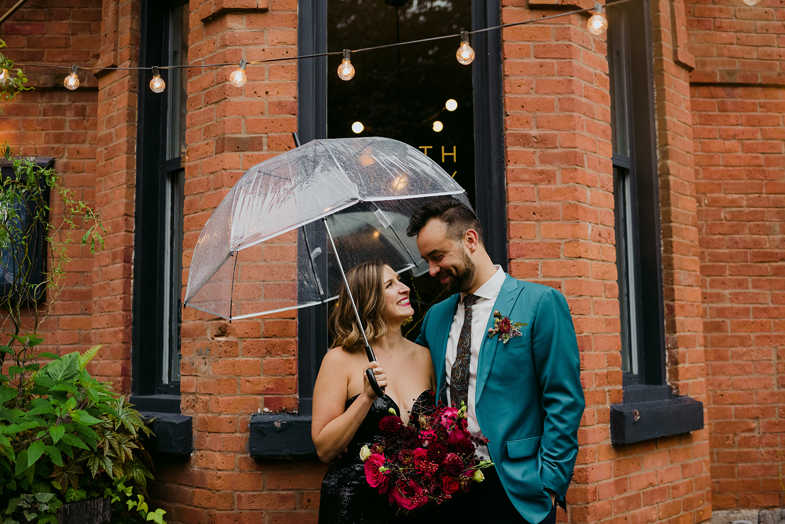 bride and groom under umbrella outside North and Navy in Ottawa