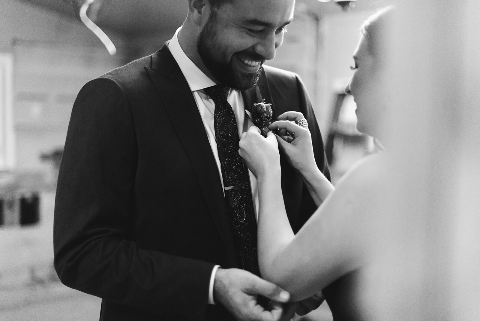 Bride helping groom with his boutonniere