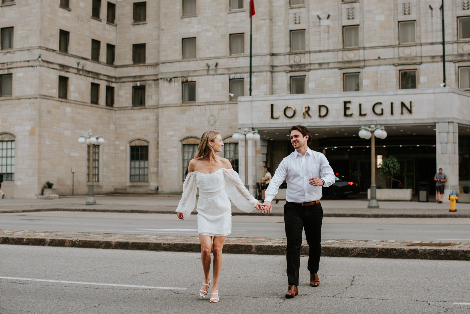 engaged couple crossing elgin street in front of the Lord Elgin Hotel