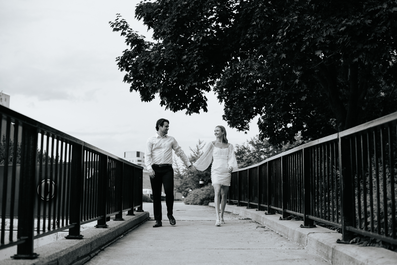 engaged couple walking down path in black and white