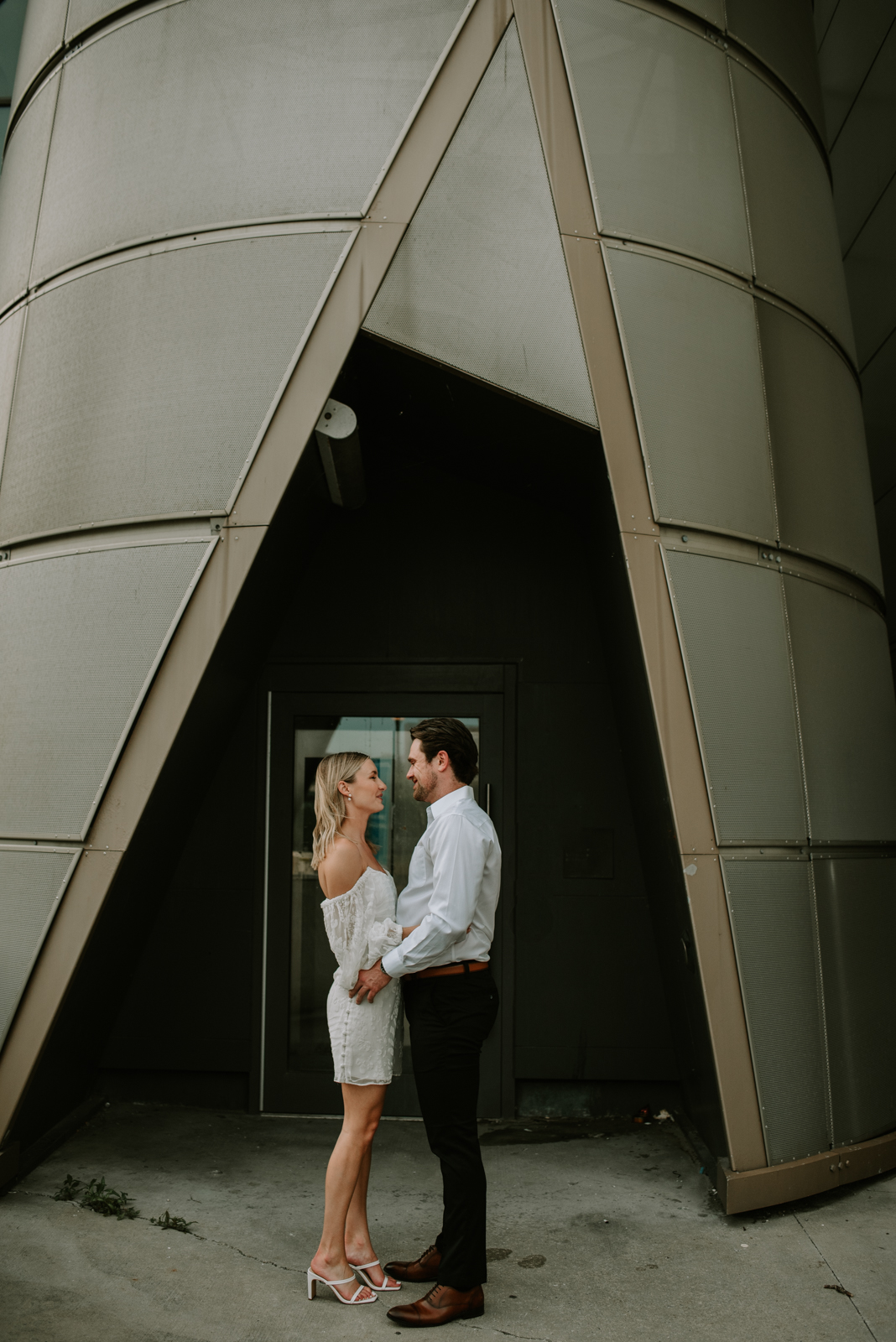 engaged couple standing by tower
