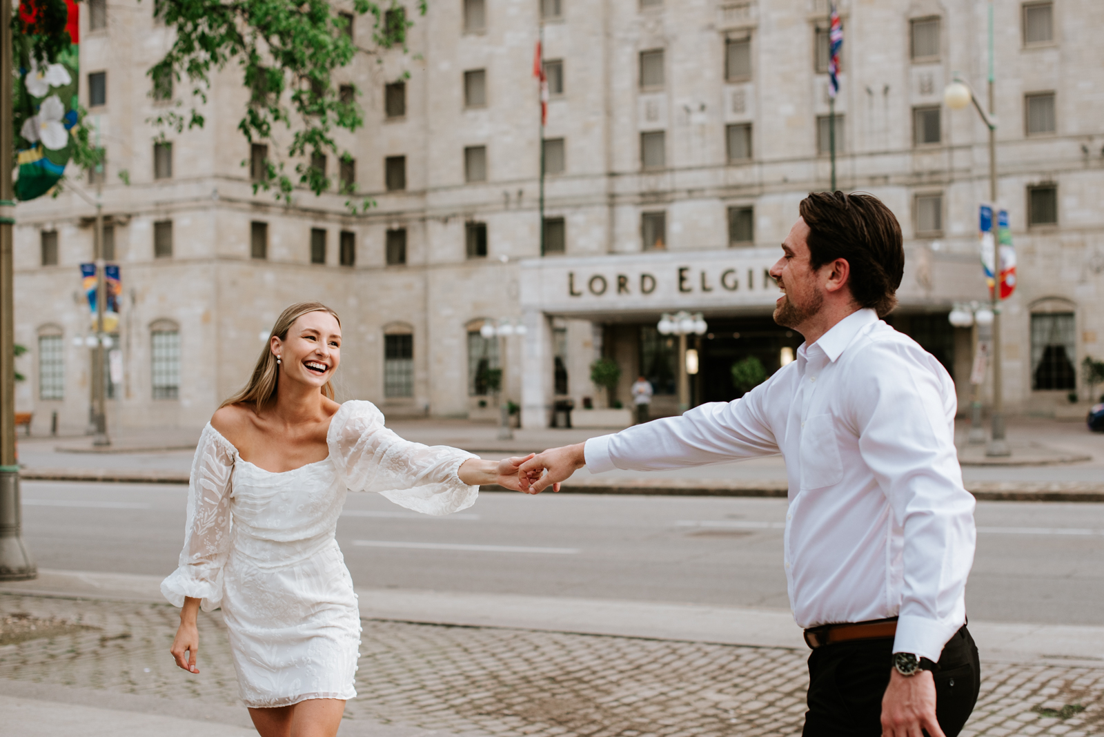 engaged couple dancing in front of the Lord Elgin Hotel