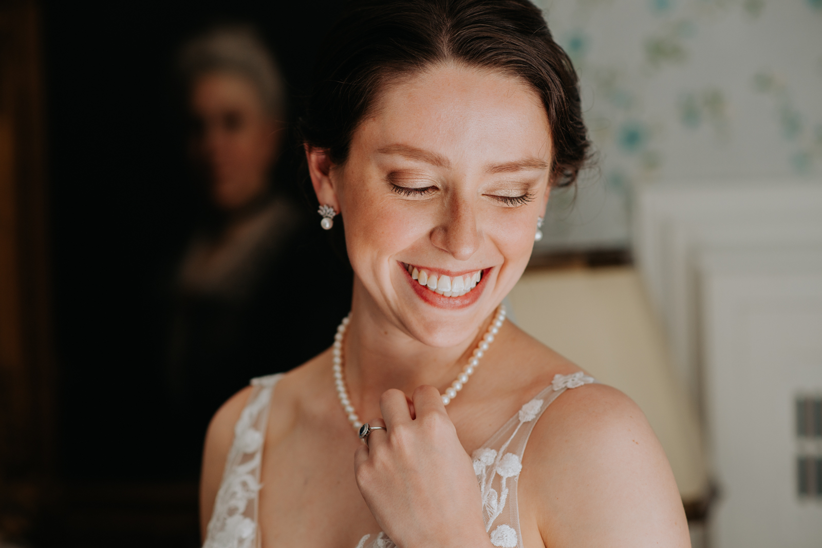 bride playing with her pearl necklace laughing