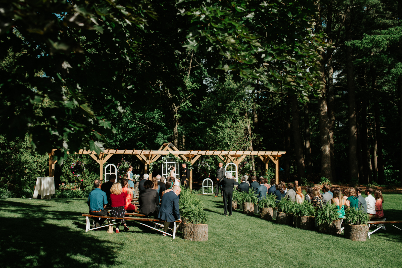 outdoor wedding ceremony under wooden arbour