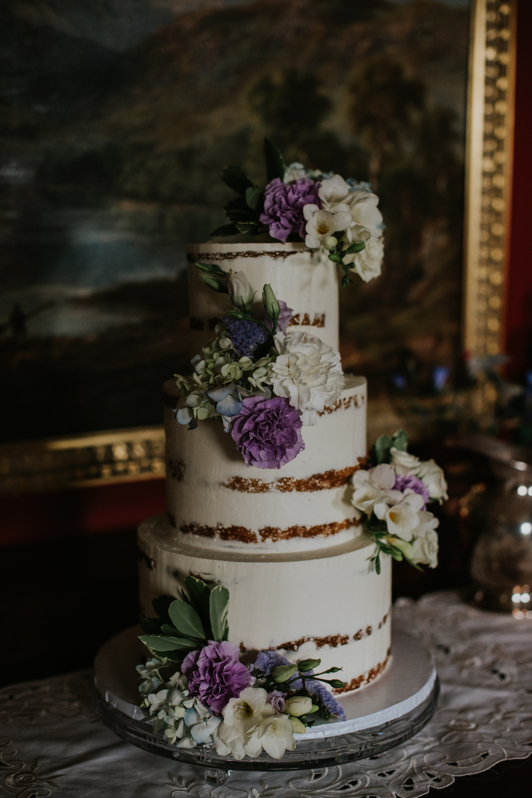 3 tier wedding cake with purple and white flowers