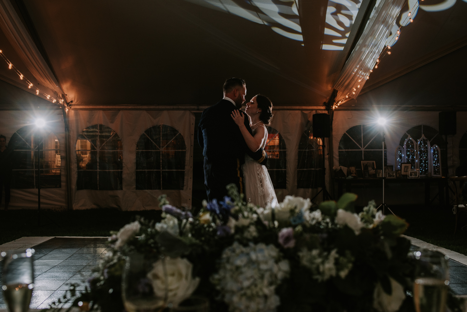 bride and groom first dance underneath a tent