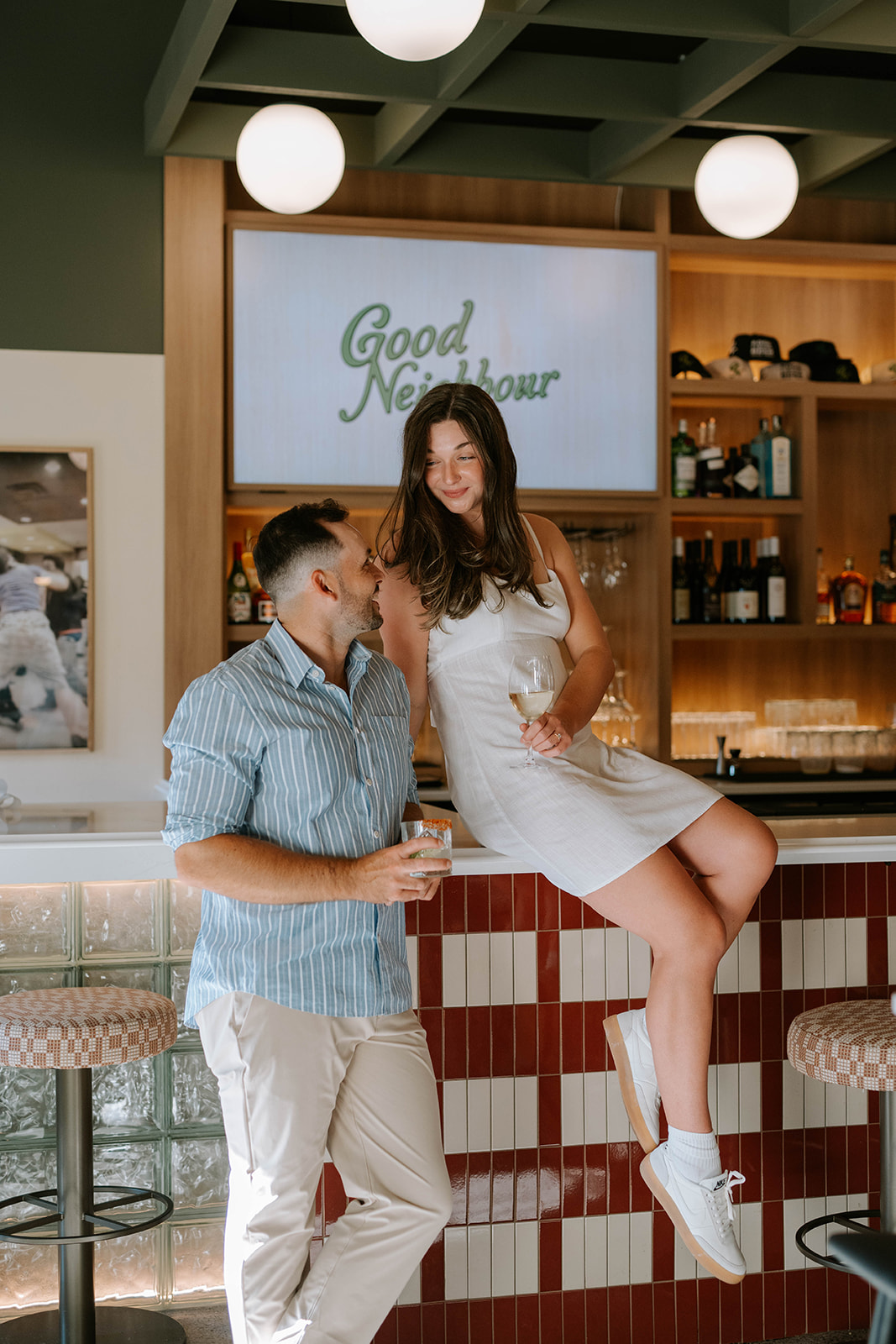 girl sitting on the bar during restaurant engagement photos